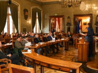 sala obrad, przy pulpicie osoba przemawiająca